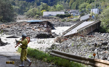 吾妻川に崩落した国道144号。濁流は近くの自動車整備工場や資材置き場ものみ込んだ＝13日午前11時35分ごろ、嬬恋村の画像