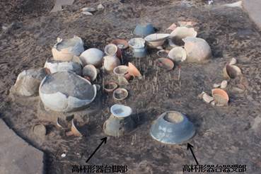 写真9：須恵器高杯形器台を含む祭祀土器群（竹串は臼玉出土位置）の画像