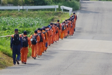 隊列を組んで歩みを進める学生の写真