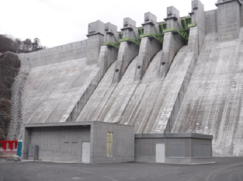 八ッ場ダムを背景にした八ッ場発電所の写真