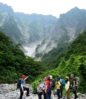 圧巻の一ノ倉沢を前に谷川岳の歴史や自然を学ぶ参加者の写真