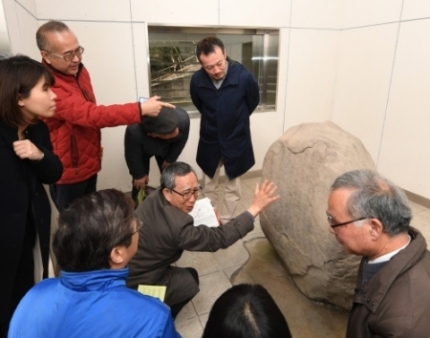 金井沢碑を見ながら意見を交わす日中韓の専門家らの写真