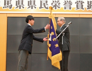 前橋育英高校サッカー部の田部井涼前主将に県民栄誉賞旗を贈呈する大澤正明知事（2月21日県庁）の写真