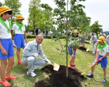 子どもたちとハナミズキを植樹する大澤知事の画像