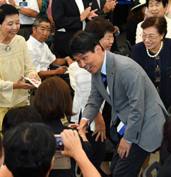 初登庁セレモニーで支援者の握手に応じる山本知事の写真