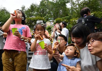 御巣鷹の尾根の昇魂之碑の前でシャボン玉を飛ばす子どもたちの写真