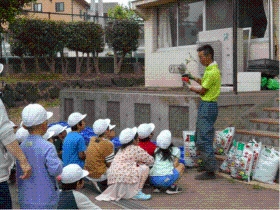 クラブ員の説明を真剣に聞く小学生の写真