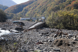 写真：国道144号の鳴岩橋崩落現場を視察する山本知事と赤羽大臣