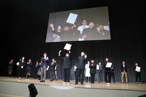 写真：大賞を受賞した伊勢崎商業高校の並里さん、向山さんを祝福する山本知事