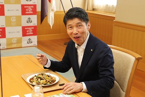 写真：「ズッキーニ入り回鍋肉」を試食する山本知事