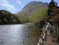 弥陀ケ池から見る日光白根山のピークの写真