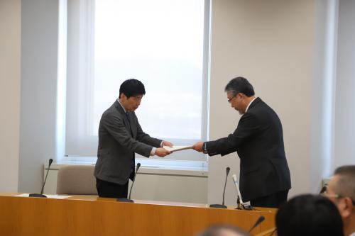 写真：委員長から報告書を受け取る山本知事