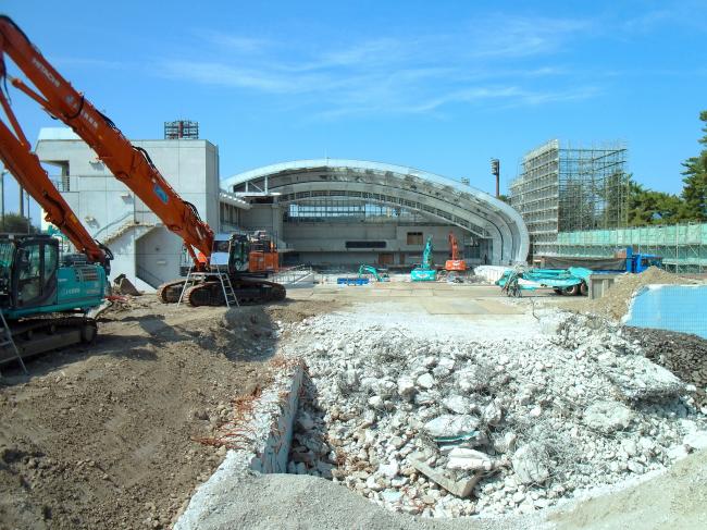 解体中の敷島水泳場 プール外観と重機と青空の画像