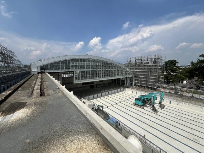 ガラス張りの屋根と空のプールの中に重機がある画像