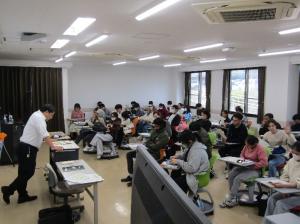 県警講師と講話を傾聴する学生の写真