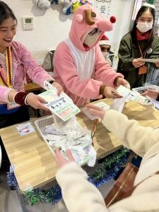 学生が来場者へ啓発リーフレットを手渡す様子の写真